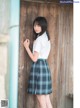 A young woman leaning against a wooden door.