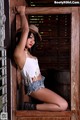 A woman in a cowboy hat leaning against a wooden door.